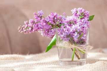 Purple and pink lilac flowers in a glass vase. Bouquet of lilac for mother or wife concept. Copy space.