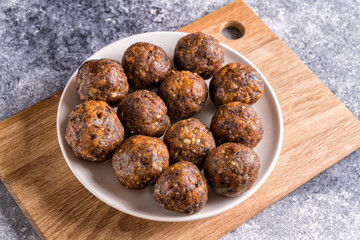 Fruit and nut energy balls in a plate, flat lay.