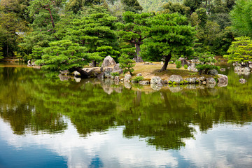 Japanese ornamental garden  with Japanese white pines and lake near Kinkakuji Temple (kinkaku-ji) in Kyoto, Japan.
