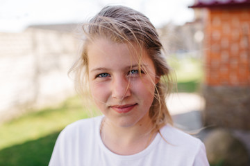 portrait of blue-eyed girl. little blond girl with disheveled hair. serious girl face expression