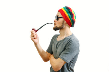 Young caucasian rasta man in jamaica hat, sunglasses and grey t-shirt on white background with...