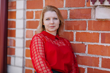 beautiful woman in red blouse. wrinkles on woman's face. blonde in a red blouse. a good looking mom