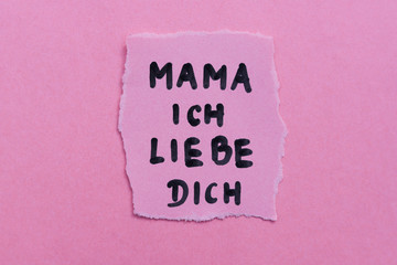 Piece of paper with text I love you mama in German. Motherday concept.