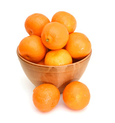 orange mandarines heap in wooden bowl on white