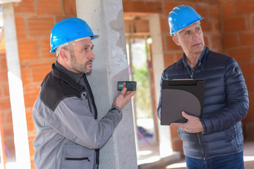 Architect is supervising the measurements in a construction site