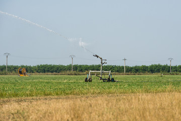 Jet of water gushing out of the irrigation system working on a field