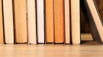 Person taking a book off a bookshelf in a library or book shop. Close up.