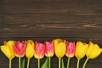  Yellow and pink tulips on wooden table with space for text 