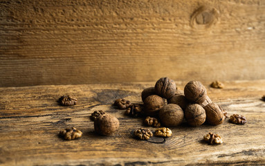 Walnut scattered on the wooden vintage table. Walnuts is a healthy vegetarian protein nutritious food. Walnut on rustic old wood.