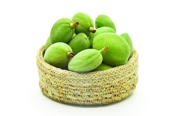 some green almonds with basket on a white background