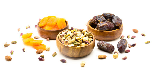 Mix of nuts and dried fruits on a old rustic table. Gold pistachios, cashews, hazelnuts, almonds. Food background.