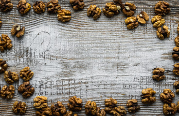 Walnut scattered on the wooden vintage table. Walnuts is a healthy vegetarian protein nutritious food. Walnut on rustic old wood. Copy space.