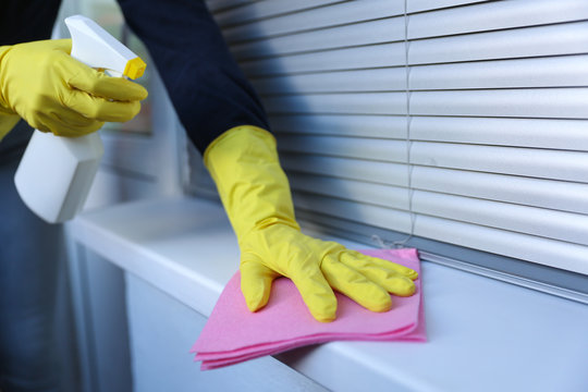 cleaner's hands in rubber yellow gloves doing disinfection cleaning with detergent spray and rag. preventive measures against covid-19