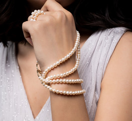 woman with pearl diamond necklace in hand