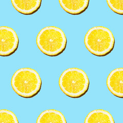 Fototapeta na wymiar Trendy sunlight Summer pattern made with yellow lemon slice on bright light blue background. summer concept.