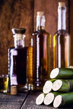 sugar cane used in distilled beverages, rustic wooden setting, still.