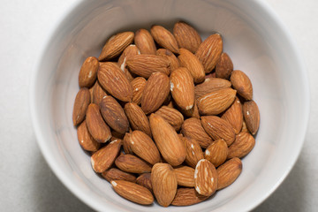 A white bowl of almonds