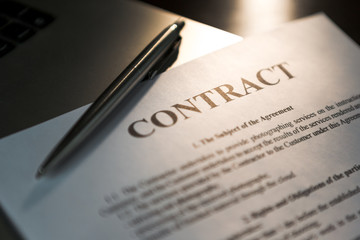 Pen for signing the contract. The pen and contract are on the laptop.