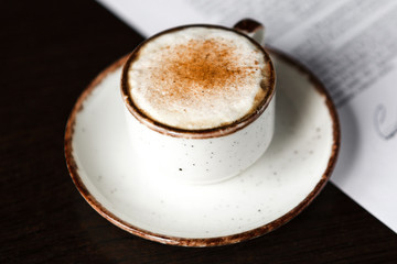 cup of coffee with foam, ballpoint pen, blank contract on a wooden table