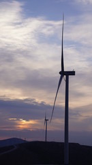 Wind turbines are generating power at sunset background. The concept of clean and renewable energy.