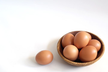 chicken eggs on a wooden saucer on a white background