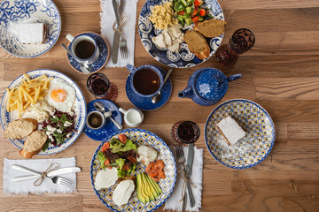Poached eggs with salmon and avocado on sourdough toast isolated on wooden background. Homemade food. Top view. eating and leisure concept - group of people having dinner at table with food