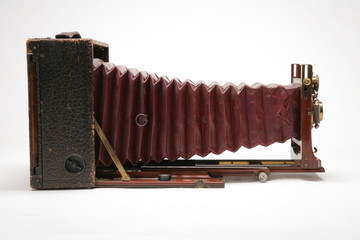 Side view of vintage large-format view camera with bellows partially extended. Isolated shot on...