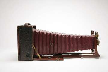 Vintage large format view camera with bellows extended. Side view shot of white background