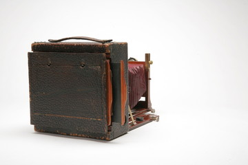 View from back of Vintage, large-format, 4x5, glass negative, view camera. Red leather bellows partially extended forward. Isolated shot on white background.