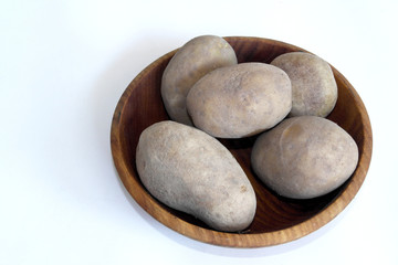 fresh potatoes on a wooden plate