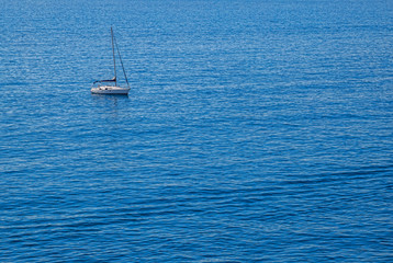 lonely yacht in middle in blue clear sea