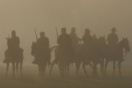 American Civil War Horseback Riders Prepare To Advance In Battle. Silhouetted By A Smoky Haze.