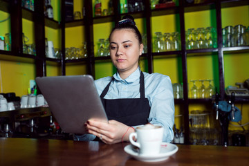 Fototapeta na wymiar Female waiter using tablet at cafe shop