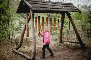 Fototapeta premium Girl enjoying activity in the adventure forest on a spring day. Childhood, lifestyle. 