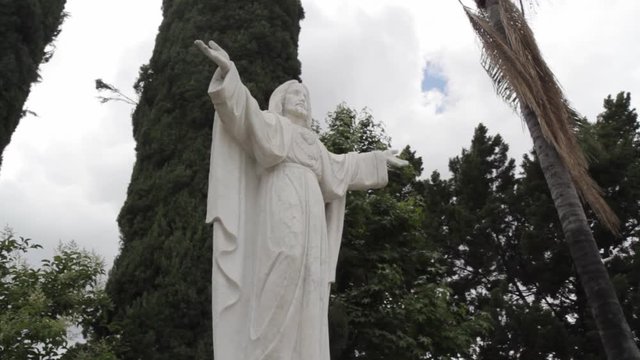 Jesus Christ Statue Outside of Church Garden with Clouds and Trees in background_Slider Pan HD