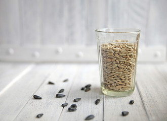 sunflower seeds in a transparent glass on a white background
