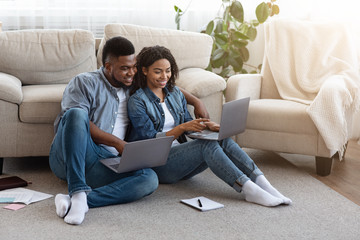 Obraz premium Remote Work. Black Couple Using Laptops At Home, Working Online Together