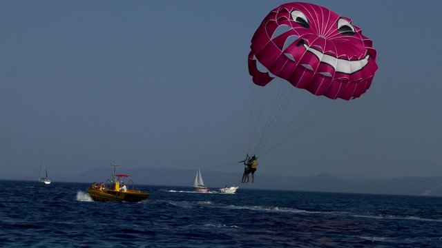 Couple starting boat parachute together going up on the air with the power of motorboat