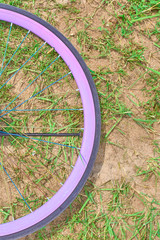 Part of the Bicycle wheel on the grass with sand