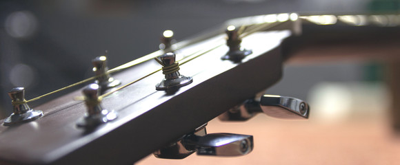 The upper part of the classical guitar, metal, shiny tunes, guitar detail.