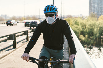 Cyclist in smog blanketed city in N95 mask. Air pollution. Industrial city. Man in mask from dust....