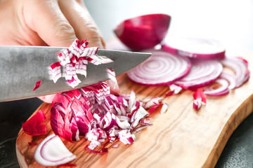 Obraz na płótnie Canvas Man hands cutting red fresh onion with knife