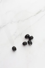 Marinated black olives isolated on white background. top view Pile of black olives. Black olives - appetizers. Flat lay, top view. Food background.