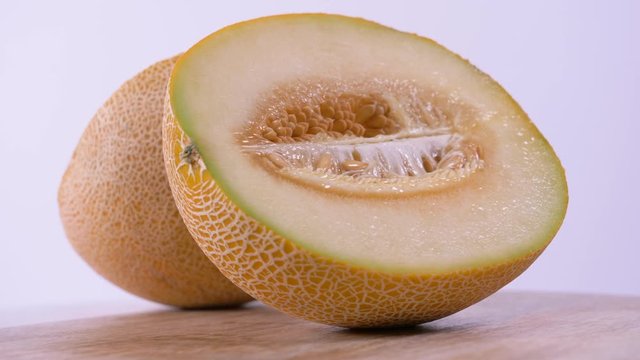 Fresh Cantaloupe Melon Sliced in Half Spinning on White Background, Cantaloupe