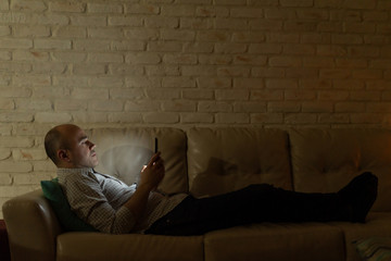 Fototapeta na wymiar Attractive man using an e-reader at night