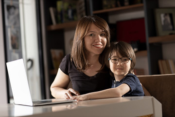 Fototapeta na wymiar Mother and boy studying with laptop in home.