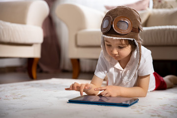 Little boy watching digital tablet in sofa.