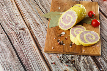 Rolled Stuffed Chicken Breast. Chicken or Turkey Roulade. Low Carb Chicken Roll Ups with cheese on a wooden table with addition of fresh herbs and aromatic spices. Natural product from organic farm.