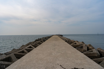 Fototapeta na wymiar ローアングルで撮影した海に伸びる防波堤