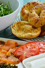 Platter of gravlax salmon slices with tomatoes, onion, cheese, salad and toasted bagels